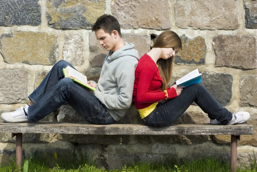 a boy and girl teen reading a book