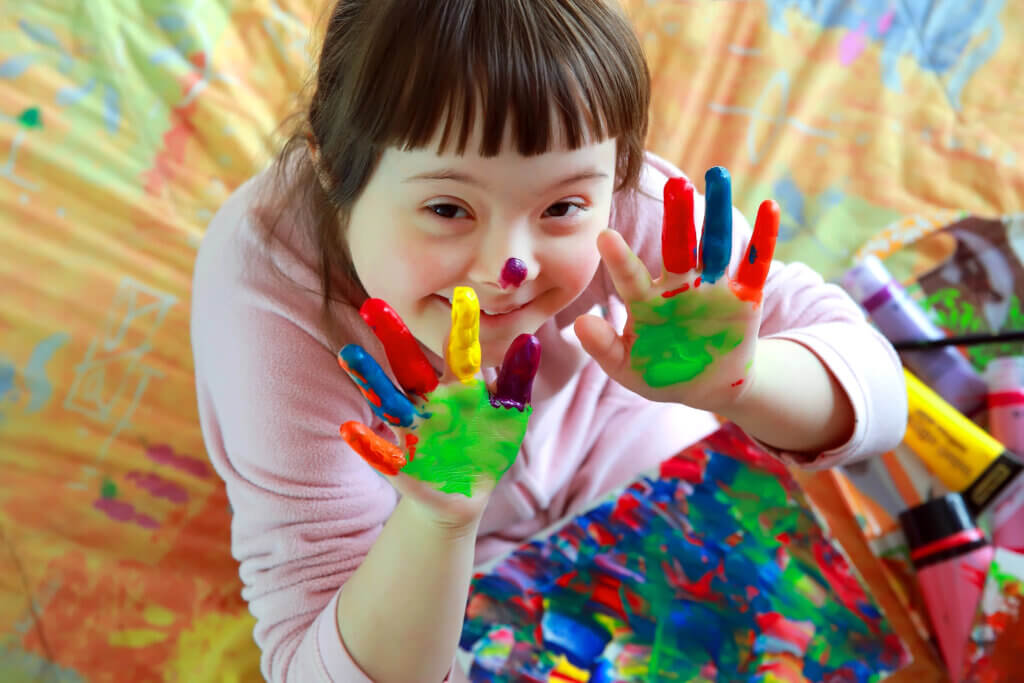 Girl with special needs playing with paint